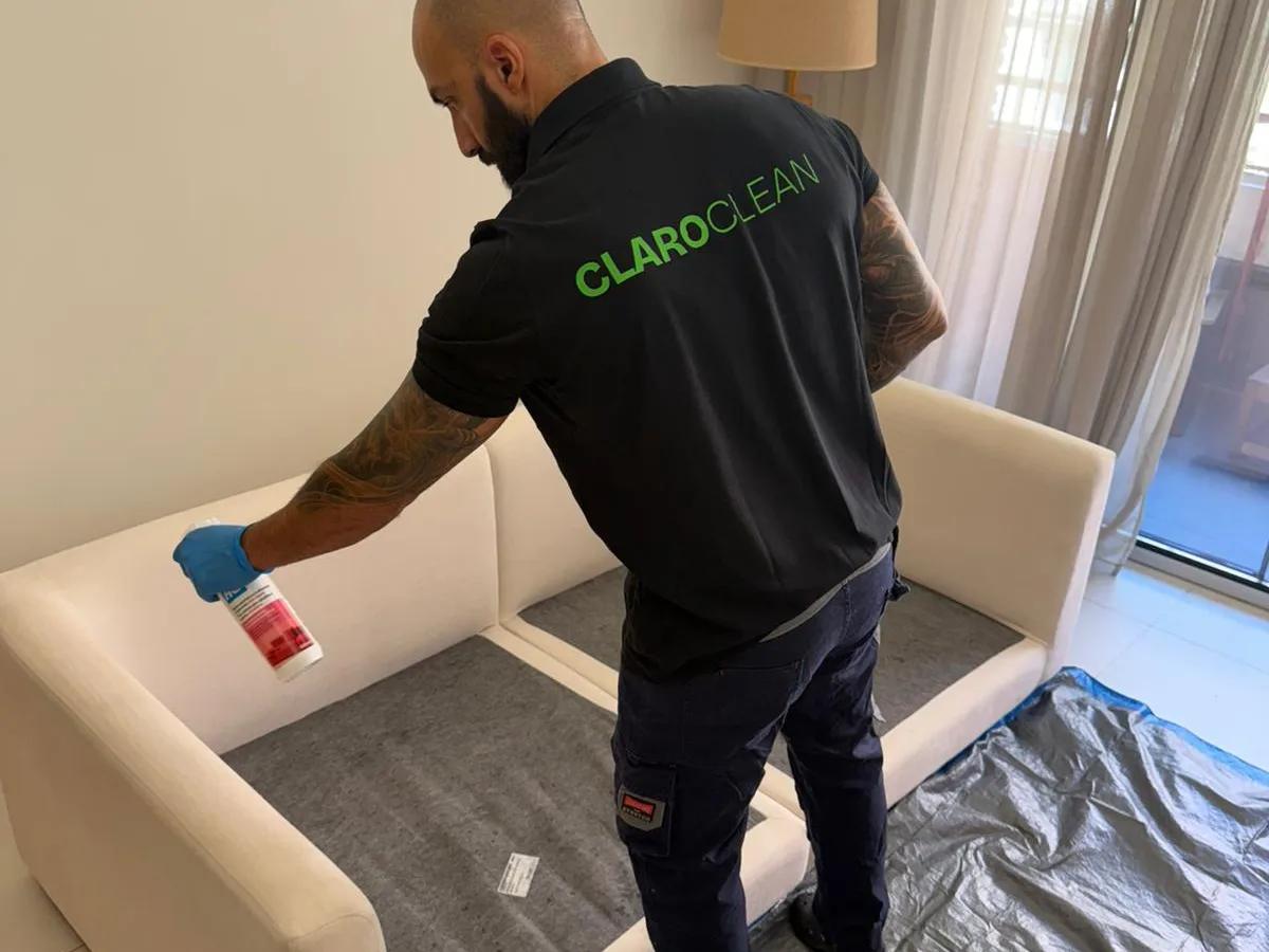 Vakman van Claro Clean behandelt een stoffen bank
